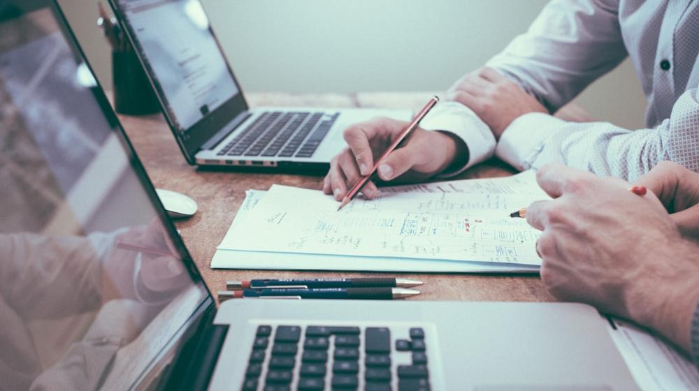Professional reviewing planning notes and a service checklist at a desk